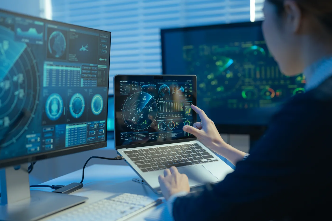 Analyst reviewing connected information systems and dashboards